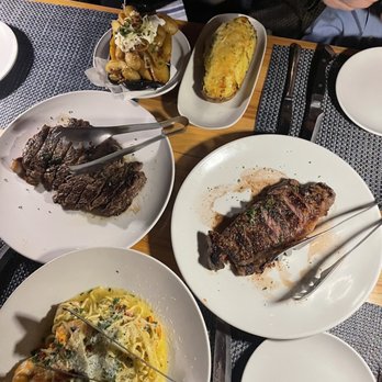 Ray's At Killer Creek - Delmonico ribeye( left), New York strip (right), Shrimp scampi linguini, Gouda twice baked potato, and loaded crispy potatoes - Steakhouses Near Me - Alpharetta, Georgia Ray's At Killer Creek - Delmonico ribeye( left), New York strip (right), Shrimp scampi linguini, Gouda twice baked potato, and loaded crispy potatoes - Steakhouses Near Me - Alpharetta, Georgia