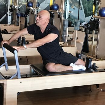 Club Pilates - Instructor Octavio is showing a sample how to use a reformer - Pilates Near Me - Duarte, California