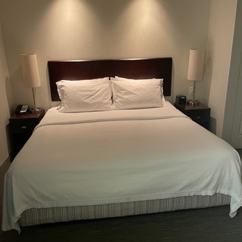 SpringHill Suites by Marriott Naples - King sized bed with two side tables and lamps with dimmer light above - Hotels Near Me - Naples, Florida
