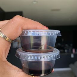 a hand holding two cups of coffee