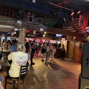Gilligan's - a group of people sitting at a bar - Nightlife Near Me - Holly Ridge, North Carolina