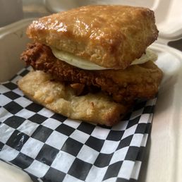 Buttery Fried chicken biscuit glazed with honey with fried egg.