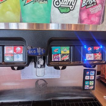 Taco Bell - Fountain sodas - A soda vending machine offering Pepsi, Mountain Dew, and other soft drinks, with illuminated selection buttons, located in a convenience store. - Fast Food Near Me - Reading, Pennsylvania
