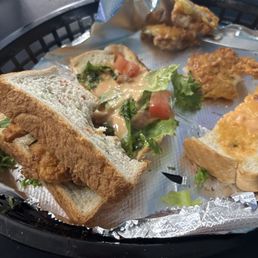 Fish sandwich with lettuce and tomato. Fish sandwich with lettuce and tomato.