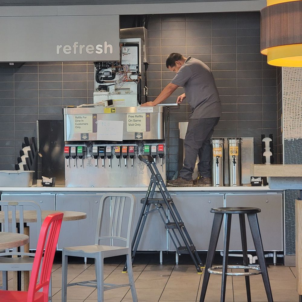 A McDonald's employee standing on the counter while the restaurant was open & customers trying to get their drinks. A McDonald's employee standing on the counter while the restaurant was open & customers trying to get their drinks.