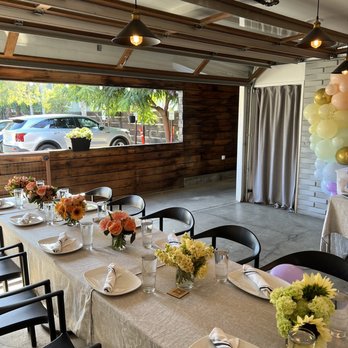 Benchmark - Modern dining room with roll up garage door opens up for ventilation and has AC for hot days - New American Near Me - Santa Ana, California
