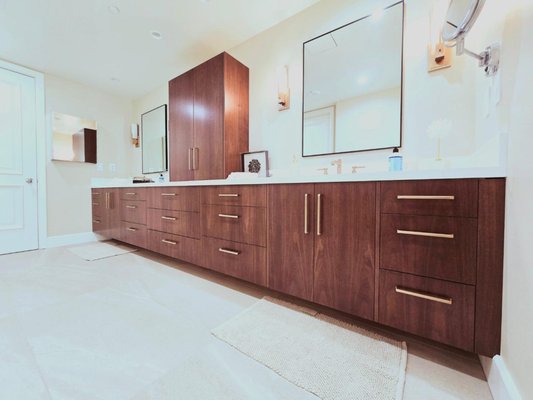 Scholarship Dr. - New primary bathroom custom cabinets for this home in Irvine, CA. Faux-inset cabinetry style, which incorporates small fillers between each frameless cabinet to give an elevated look. 

Grain matched walnut panels color matched to client specification. Lots of drawer space plus roll outs and two integrated outlets in the drawers.