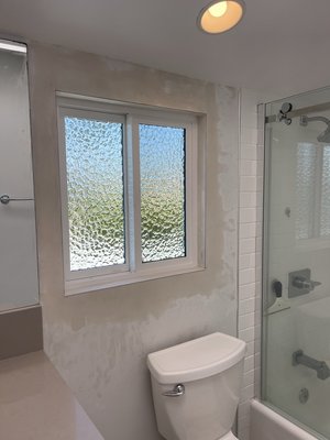 Bathroom Window Installation in Huntington Beach (Milgard Trinsic) - Our client wanted more fresh air and natural light in their bathroom while maintaining privacy. We created a new opening and installed a Milgard Trinsic window using our new construction installation method, including a stucco patch on the exterior and a smooth drywall return on the interior. The window features upgraded privacy glass for light and discretion. Milgard Trinsic windows include a full lifetime warranty with an optional glass breakage warranty for added peace of mind.