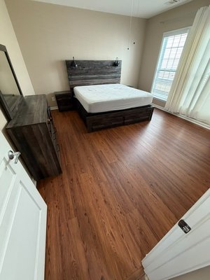 Project #210 - This LVP flooring project features a warm, natural wood-look finish installed throughout multiple bedrooms and closet areas. The consistent plank layout creates a smooth, cohesive flow from room to room while giving the space a clean and updated appearance. The finished floors combine the look of hardwood with the durability and easy maintenance that make LVP a practical choice for everyday living.