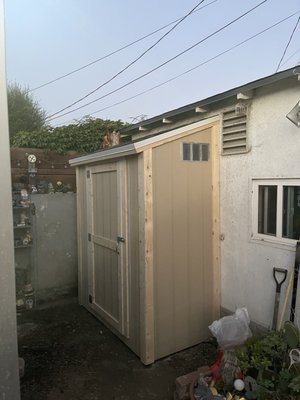 Custom Size Shed without paint - This Customer wanted a custom dimension size to fit into a really tight space. I suggested to maximize storage space and go with higher walls. He liked the idea and we built a 8-foot-tall rear wall and slopped it down to a 7-foot wall. The shed is a custom sized 8x3 built to fit specifically in this tight space. It has two shelves inside to help with organization.