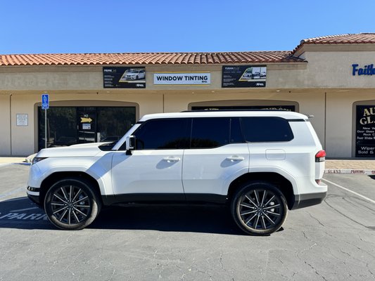 Limo-Tint Transformation - This 2024 Lexus GX450 received a complete limo-tint upgrade using XR Black Ceramic film. XR Black Ceramic is one of the best tints available, combining sleek style with advanced protection. Known for its high heat rejection, this film blocks up to 88% of infrared heat, keeping the interior cool even in the hottest conditions. It also offers 99% UV protection, preserving the cabin and shielding passengers from harmful sun exposure. Plus, the ceramic composition reduces glare without affecting visibility, making every drive more comfortable and protected. With XR Black, this GX450 is ready for luxury, privacy, and comfort.