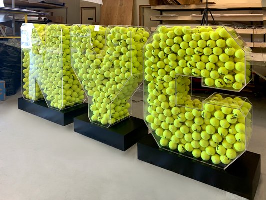 NYC Tennis Reception Party - Tennis balls encased in acrylic letters spelling out NYC - We brought to life a very creative idea for this tennis event featuring the letters NYC. The base of this freestanding sign was made of durable aluminum while the outer side is made of high-quality acrylic. The ready sign was filled to the brim with bright tennis balls. We enjoyed creating this sign just as much as our customers enjoyed the final result. NYC Tennis Reception Party - Tennis balls encased in acrylic letters spelling out NYC - We brought to life a very creative idea for this tennis event featuring the letters NYC. The base of this freestanding sign was made of durable aluminum while the outer side is made of high-quality acrylic. The ready sign was filled to the brim with bright tennis balls. We enjoyed creating this sign just as much as our customers enjoyed the final result.