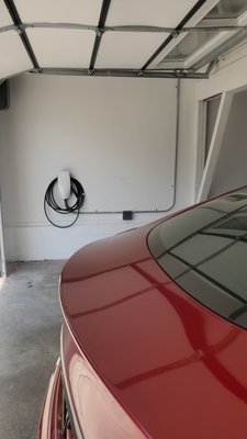 Tesla Wall Connector, aka level 2 EV charger - There was no attic space available in this garage to conceal the wiring for this Tesla level 2 charger. In situations like this, conduit on the surface of the wall is an efficient way to route the wiring to the location that a customer prefers to have their charger installed in.