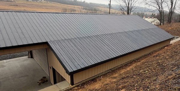 Pole Barn Roof Extension in Pine Grove, PA - This Pine Grove homeowner wanted to create additional covered storage space by extending the roof along the side of an existing pole barn.
This project required more than simply adding roofing panels. Our crew framed the new wall and roof extension so the existing roofline and pitch could continue properly across the addition.
Once the new structure was framed, we finished the exterior with tan metal wall panels and black metal roofing, along with coordinating black fascia and corner trim, tan J-channel and rat guard, and new soffit.
Although this project was a little different from the roof replacements our crews complete every day, it was a great opportunity to put their carpentry and exterior construction experience to work.
The finished addition provides the homeowner with additional covered space while looking like a natural extension of the existing pole barn.
Thank you to our Pine Grove homeowner for trusting Martin Roofing & Siding with the project!
Family-owned and serving Pine Grove and Schuylkill County since 1992.