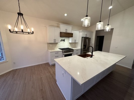 Eagle Idaho Kitchen Transformation - To bring this kitchen to life, we removed barriers, expanded workspace, and brightened the entire space. A large quartz island became the new centerpiece, creating an open and inviting layout. Fresh white cabinetry, sleek black hardware, and a custom wood range hood added style and warmth. Modern lighting and premium finishes completed the transformation, turning this kitchen into a showpiece of both beauty and functionality. Eagle Idaho Kitchen Transformation - To bring this kitchen to life, we removed barriers, expanded workspace, and brightened the entire space. A large quartz island became the new centerpiece, creating an open and inviting layout. Fresh white cabinetry, sleek black hardware, and a custom wood range hood added style and warmth. Modern lighting and premium finishes completed the transformation, turning this kitchen into a showpiece of both beauty and functionality.