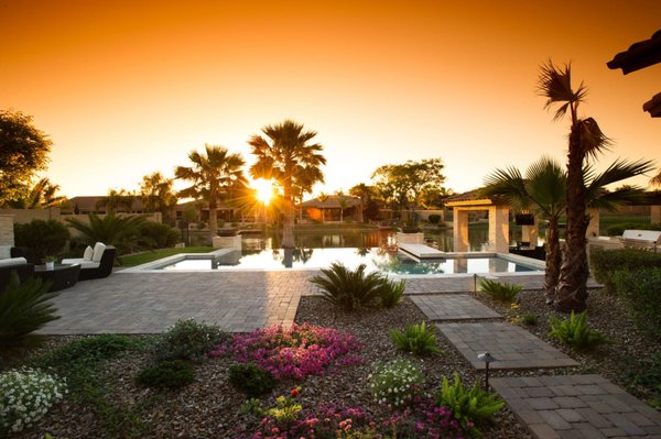 Lakeside Infinity Inground Pool Installation Project - This lakeside gem is a stunning example of California Pools & Landscape’s expertise in inground pool installation and seamless blending of natural beauty with modern design. Our client’s lakeside view became the centerpiece as we created a space reflecting their strong style.
Our clients, an artistic couple with high standards and a keen design sense, collaborated with us to design a backyard mirroring their personalities. They encouraged our new pool builders to push the envelope with materials and approach, allowing us to incorporate cutting-edge elements throughout.
The modern swimming pool features a dramatic negative edge, with the pool’s water dropping off seamlessly into the lake vista. The unobstructed layout, with no fencing, provides a sense of continuity and spaciousness, perfect for relaxing and enjoying the view.
Using the property’s unique topography, we created a multi-tiered design highlighting different gathering areas. From a chic swim-up bar, guests can step down to a modern, multi-level outdoor kitchen with a trash chute, drawers, and cocktail area. Further down is a covered fire pit with an entertainment area, widescreen TV, and glam overhead lighting. The final level leads to the spacious lakefront, all creatively arrayed under a tiled gazebo matching the home’s roof.
To keep the project on budget, we matched the existing dark, rustic pavers and added a fresh, modern feel with white travertine on the pool and white Marbella stackstone. This combination provided the clean look our clients desired while complementing the existing pavers.
Our clients wanted a Mediterranean feel, so we added bright desert wildflowers lining the path to the pool, enhancing the landscape’s vibrancy. Finishing touches included a modern wall with a wide window showcasing potted succulents.
Despite the property’s strict homeowners’ association, we met their rigorous requirements while satisfying our client’s vision. From tree and grass species rules to setback policies and other technical requirements, we maintained the glamour of our design.
This rewarding project resulted in a perfect sanctuary for our clients to relax, entertain, and spend time with family. California Pools & Landscape excels in luxury pool installation and infinity pool building, creating spaces for you to make memories for years to come. Whether it’s inground pool installation or inground hot tub installation, we are here to bring your vision to life. Lakeside Infinity Inground Pool Installation Project - This lakeside gem is a stunning example of California Pools & Landscape’s expertise in inground pool installation and seamless blending of natural beauty with modern design. Our client’s lakeside view became the centerpiece as we created a space reflecting their strong style.
Our clients, an artistic couple with high standards and a keen design sense, collaborated with us to design a backyard mirroring their personalities. They encouraged our new pool builders to push the envelope with materials and approach, allowing us to incorporate cutting-edge elements throughout.
The modern swimming pool features a dramatic negative edge, with the pool’s water dropping off seamlessly into the lake vista. The unobstructed layout, with no fencing, provides a sense of continuity and spaciousness, perfect for relaxing and enjoying the view.
Using the property’s unique topography, we created a multi-tiered design highlighting different gathering areas. From a chic swim-up bar, guests can step down to a modern, multi-level outdoor kitchen with a trash chute, drawers, and cocktail area. Further down is a covered fire pit with an entertainment area, widescreen TV, and glam overhead lighting. The final level leads to the spacious lakefront, all creatively arrayed under a tiled gazebo matching the home’s roof.
To keep the project on budget, we matched the existing dark, rustic pavers and added a fresh, modern feel with white travertine on the pool and white Marbella stackstone. This combination provided the clean look our clients desired while complementing the existing pavers.
Our clients wanted a Mediterranean feel, so we added bright desert wildflowers lining the path to the pool, enhancing the landscape’s vibrancy. Finishing touches included a modern wall with a wide window showcasing potted succulents.
Despite the property’s strict homeowners’ association, we met their rigorous requirements while satisfying our client’s vision. From tree and grass species rules to setback policies and other technical requirements, we maintained the glamour of our design.
This rewarding project resulted in a perfect sanctuary for our clients to relax, entertain, and spend time with family. California Pools & Landscape excels in luxury pool installation and infinity pool building, creating spaces for you to make memories for years to come. Whether it’s inground pool installation or inground hot tub installation, we are here to bring your vision to life.