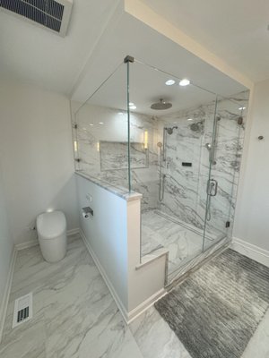 Lake Forest Primary Bathroom Remodel - These Lake Forest homeowners wanted to transform their primary bathroom into a more functional and updated space. Regency stepped in to help our clients design and execute the bathroom of their dreams. The old cabinetry was replaced with Regency's smart navy blue cabinets, fitted with Kohler sinks and Hansgrohe faucets from Studio 41. Daltile's stunning White Pearl Quartzite countertops completed the beautiful new vanity. The striking new shower features tiles from The Tile Shop, with accents of Daltile's White Pearl Quartzite on the shower bench, curb, and niche to match the vanity top. Lake Forest Primary Bathroom Remodel - These Lake Forest homeowners wanted to transform their primary bathroom into a more functional and updated space. Regency stepped in to help our clients design and execute the bathroom of their dreams. The old cabinetry was replaced with Regency's smart navy blue cabinets, fitted with Kohler sinks and Hansgrohe faucets from Studio 41. Daltile's stunning White Pearl Quartzite countertops completed the beautiful new vanity. The striking new shower features tiles from The Tile Shop, with accents of Daltile's White Pearl Quartzite on the shower bench, curb, and niche to match the vanity top.