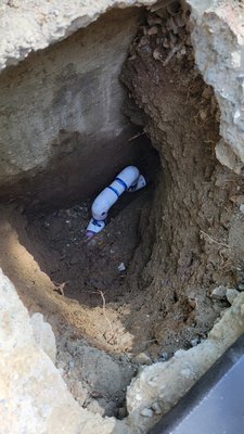 Main Line Repair - The customer has concerns with excessive water usage and visible water pooling next to driveway. The driveway is elevated with crushed rock below which acts as French drainage given the hillside. Using an ultra sonic listening device we located the area of highest readings on the aggregate driveway between the trench drain in ground and railing along driveway. Leak location was marked, cut open, repaired and concrete patched.