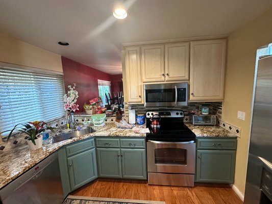 Reface in Martinez - Client in Martinez tired of their old dark oak cabinets had them refaced adding some beautiful green and light wood tones to go with their existing counters and backsplash.