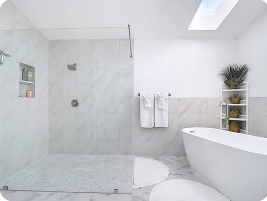 Bathroom Remodel - 2025 - This large bathroom had plenty of square footage but much of it was underutilized. The space featured an older vanity with cracked granite, outdated sinks and fixtures, a small corner shower with dark 90’s‑style tile, a worn ceramic standalone tub, dated lighting, and older rectangular mirrors. The homeowners wanted a modern, spa‑inspired layout that made better use of the room.

We removed the existing shower, tub, vanity, lighting fixtures, and mirrors to prepare the space for a full redesign. A new larger frameless shower was installed with sliced pebble mosaic flooring, wall‑to‑wall porcelain tile, and matching half‑height porcelain tile wrapping behind the toilet and extending to the vanity. A new stone‑resin standalone tub was added with an updated tub faucet to replace the worn original. The custom wall‑mounted dual‑sink vanity features a quartz countertop and modern fixtures, paired with contemporary half‑moon mirrors for a clean, architectural look. New porcelain tile flooring and LED lighting fixtures complete the transformation.

The result is a bright, modern bathroom with upgraded materials, a more efficient layout, and a refined, spa‑like atmosphere.