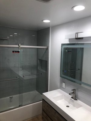 Bathroom Remodel - In this project we remodeled a guest bathroom. New tub,subway tiles ,waterproof laminate and new double sink vanity.