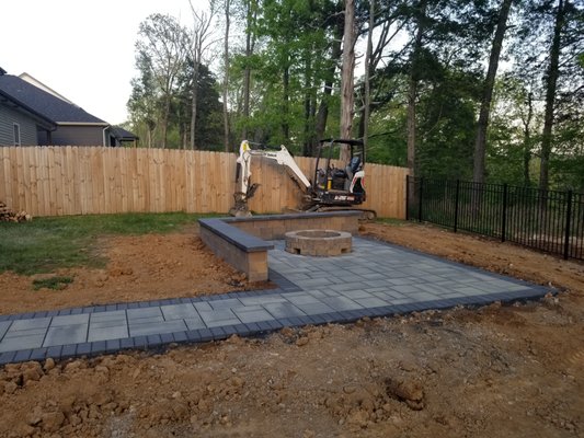 Paver Patio Install - This installation was completed in Clarksville Tennessee. We installed a Paver patio with a walkway, a 12 foot seating wall and a round fire pit. This outdoor living space added a lot of usable space to the back yard. The patio, seating wall and fire pit gave the client plenty of space for seating when inviting guests over. Most importantly, this Hardscape install gave the client a place to enjoy their evening around an evening fire peering over the cliff and down to the river in their backyard. Paver Patio Install - This installation was completed in Clarksville Tennessee. We installed a Paver patio with a walkway, a 12 foot seating wall and a round fire pit. This outdoor living space added a lot of usable space to the back yard. The patio, seating wall and fire pit gave the client plenty of space for seating when inviting guests over. Most importantly, this Hardscape install gave the client a place to enjoy their evening around an evening fire peering over the cliff and down to the river in their backyard.