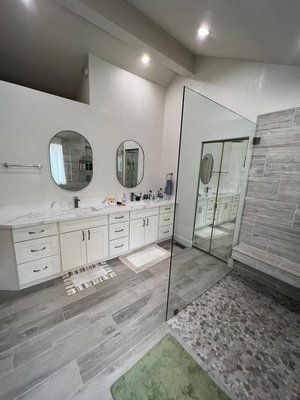 Bathroom Remodel - This remodel consists of a full bathroom remodel. In this remodel is a walk-in shower that has a shampoo niche and bench, double sink vanity, and a waiting bench outside the shower. 
Beautiful white marble bathroom remodel that features a double sink floating vanity, light-up led vanity mirror, and a white garden tub. The walk-in shower features a bench and a waterfall showerhead.