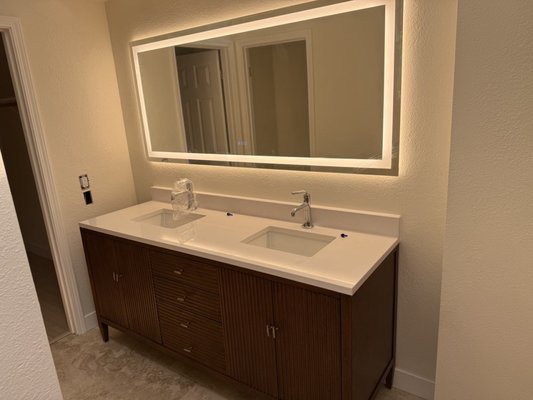 Bathroom Vanity Installation - In this project, the client provided photos of the existing bathroom condition. The following images show the transformation and installation process.

We performed adjustments to the water supply and drain connections, installed new sinks and faucets, and completed the vanity setup. A backsplash was installed for a clean finished look, along with a mirror featuring built-in lighting and a hidden electrical outlet.

The project was completed with attention to detail to ensure both functionality and a modern, clean appearance.