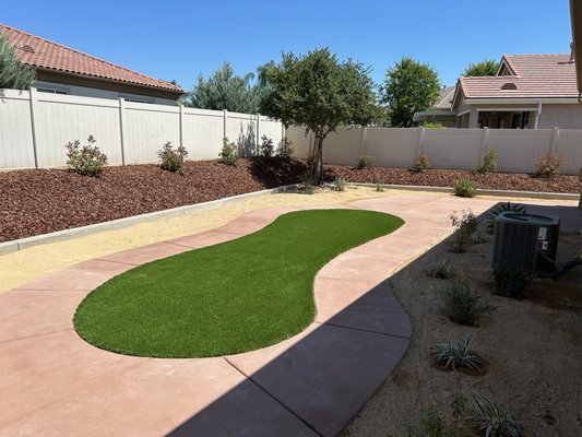 Backyard Hardscape & Low Water Landscape Project - Our customer was looking for a complete overhaul and renovation of their backyard area and side yard area. We started by increasing the back patio living area with a new custom concrete patio and walkways. We then replaced the previous lawn area with a new pet friendly artificial turf installation. We then removed all existing bushes on the low ground area and installed a new low maintenance California Gold decomposed granite, low water bushes, 2 trees and a new drip irrigation system. We lastly removed all of the property line hedge plants and planted in new large red tip photinia bushes, a weed barrier and new bark, with a modified irrigation system off the new drip irrigation system installed on the lower flower beds. The customer was very happy with the outcome and was amazed with the level of transformation she has in using the new backyard. We look forward to helping you with your next landscape and hardscape transformation as well. Backyard Hardscape & Low Water Landscape Project - Our customer was looking for a complete overhaul and renovation of their backyard area and side yard area. We started by increasing the back patio living area with a new custom concrete patio and walkways. We then replaced the previous lawn area with a new pet friendly artificial turf installation. We then removed all existing bushes on the low ground area and installed a new low maintenance California Gold decomposed granite, low water bushes, 2 trees and a new drip irrigation system. We lastly removed all of the property line hedge plants and planted in new large red tip photinia bushes, a weed barrier and new bark, with a modified irrigation system off the new drip irrigation system installed on the lower flower beds. The customer was very happy with the outcome and was amazed with the level of transformation she has in using the new backyard. We look forward to helping you with your next landscape and hardscape transformation as well.