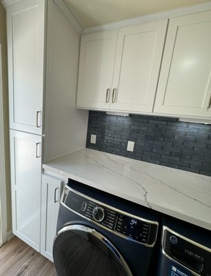 Laundry Remodel - This laundry room has been turned 360 degrees with fine finishes but above all a functional place with enough storage, a tall cabinet for brooms, a Dyson vacuum and pet food, a quartz water fall with blue live veins, under cabinet LED lighting activated with motion sensor, back splash and VLP water proof flooring