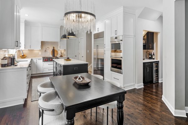 Transitional Kitchen Remodel - Transitional kitchen remodel. Black shaker cabinets. Marble countertops. White shaker cabinets. Tile backsplash. Island with seating.