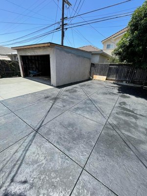 Downtown Los Angeles Project - Take a look at this stunning stamped and colored concrete patio we just completed! For this unique design, we used two distinct colors to create visual interest and define different areas of the patio. The intricate stamped pattern adds incredible texture, while the dual-tone coloring elevates the aesthetic, making the whole space pop! This custom concrete solution is not only beautiful but also incredibly durable and low-maintenance. Ready to bring your vision for a vibrant outdoor living area to life? Contact us for a custom quote! Downtown Los Angeles Project - Take a look at this stunning stamped and colored concrete patio we just completed! For this unique design, we used two distinct colors to create visual interest and define different areas of the patio. The intricate stamped pattern adds incredible texture, while the dual-tone coloring elevates the aesthetic, making the whole space pop! This custom concrete solution is not only beautiful but also incredibly durable and low-maintenance. Ready to bring your vision for a vibrant outdoor living area to life? Contact us for a custom quote!