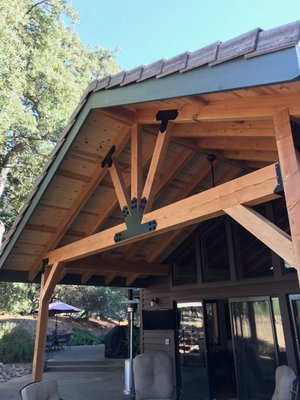 Covered Patio Replacement - This customer is going through an exterior refresh. As part of that, they wanted to rebuild their outdoor patio cover with a more grand & mountain feel. We were happy to oblige as this type work is some of our favorite to perform.
​
The existing roof cover, trusses and framing were all rotting with old age. We needed to remove the entire existing patio cover along with siding & trim. The customer opted for a more bold statement using 6x6 posts and 6x12 beams contrasted with black ironmongery. The raw finish will eventually be stained once cured. The exposed rafters and gables give an open but solid look. Adding the large fan makes for all day patio lounging. We also brought out some extra wiring for future multimedia.  
​
We are very pleased with how this turned project turned out.  And our customer is raving about the update.