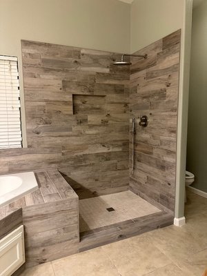 Master Bathroom Remodel - This stunning master shower and tub were finished with 6" x 36" porcelain tile, creating a sleek and elegant look. The oversized niche adds both style and practicality. Master Bathroom Remodel - This stunning master shower and tub were finished with 6" x 36" porcelain tile, creating a sleek and elegant look. The oversized niche adds both style and practicality.