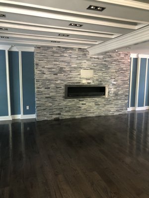 Featured stack stone wall - This home has been fully renovated, this picture features accents wall build 12 foot wall with shelves on the sides. Fire place insert. Removed wall separating two living rooms, install steel beam and trim, whole house painting.