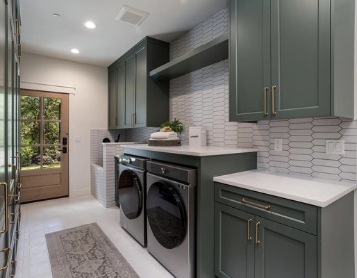 Laundry Room - We transformed this laundry room into a beautiful and functional space with a fresh, modern touch. Custom sage green cabinetry adds warmth and charm while providing plenty of storage. A sleek countertop creates the perfect spot for folding laundry with ease. We also built a custom sink complete with a tiled surround and a stunning backsplash that adds just the right amount of character and style. It’s now a space that feels just as inviting as the rest of the home! Laundry Room - We transformed this laundry room into a beautiful and functional space with a fresh, modern touch. Custom sage green cabinetry adds warmth and charm while providing plenty of storage. A sleek countertop creates the perfect spot for folding laundry with ease. We also built a custom sink complete with a tiled surround and a stunning backsplash that adds just the right amount of character and style. It’s now a space that feels just as inviting as the rest of the home!