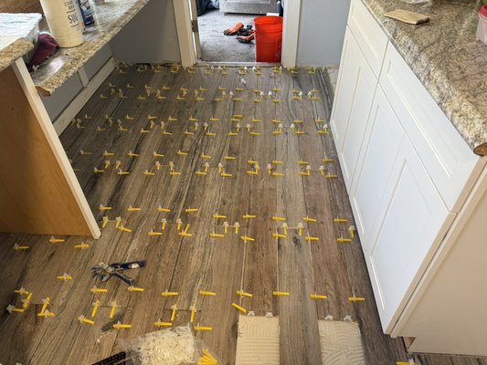Kitchen floor tile - We were called in to install tile in the kitchen, hallway, and bathroom of this family’s home. Very thankful and grateful to them for the opportunity. A beautiful tile with a wood finish, 1/16 inch grout lines with a Stone gray grout