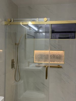 Walk-In Shower Remodel: Marble-Look Tile, LED Niche and Gold Hardware - Bathroom remodel in San Antonio, TX with a custom walk-in shower. Large-format marble-look tile, an LED-lit shower niche, brushed gold fixtures and a frameless glass enclosure. Photos show the tile installation process and the finished bathroom. Free estimates and a 1-year labor warranty. Call Yeromenko LLC to book your in-home estimate.