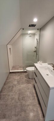 New Bathroom Project (12x40" ceramic wall tile with slated portion & 12x36" porcelain floor tile) - Brand new bathroom: 12x36" porcelain floor tile + 12x40" ceramic wall tile. A custom shower floor concrete slab was poured with a PVC mat underneath ensuring a waterproof seal. Slated wall tile was installed creating a flush finish for the shower stall. New Bathroom Project (12x40" ceramic wall tile with slated portion & 12x36" porcelain floor tile) - Brand new bathroom: 12x36" porcelain floor tile + 12x40" ceramic wall tile. A custom shower floor concrete slab was poured with a PVC mat underneath ensuring a waterproof seal. Slated wall tile was installed creating a flush finish for the shower stall.