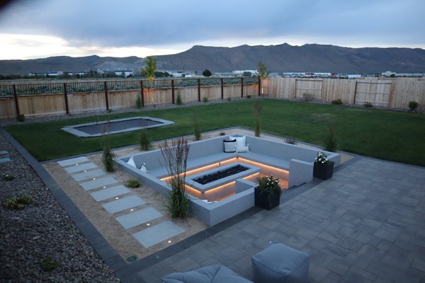 Sunken fire pit, pavers, inground trampoline - Project Overview:
Our latest endeavor was a holistic transformation of a backyard into a premium outdoor living space, designed to cater to both aesthetics and functionality. This project was a testament to our dedication to creating spaces that fuse leisure, entertainment, and natural beauty.
Features Installed:
Inground Trampoline: A highlight for family entertainment, our expertly integrated inground trampoline blends perfectly with the landscape, offering a safe and stylish solution for active play.
Custom Inground Firepit: Our inground firepit is the heart of evening gatherings, providing warmth and ambiance. It’s crafted to complement the outdoor aesthetic and become a favorite spot for relaxation and socializing.
Extensive Paver Work: The use of varied pavers to craft walkways, patios, and seating areas not only ensures longevity but also adds a distinctive charm to the outdoor space. Our bespoke designs cater to the unique dimensions and aesthetic preferences of the property.
Landscape Design with Trees and Plants: We introduced an array of trees and plants, carefully selected for their compatibility with the local environment and their contribution to the landscape’s visual appeal, ensuring a vibrant and sustainable garden.
Outdoor Lighting: Our strategically placed outdoor lighting illuminates the beauty of the yard, highlighting key features while providing safety and extending the enjoyment of the space into the evening hours.
Lush Lawn Installation: A central feature of this transformation is the lush, green lawn that serves as a versatile backdrop for the entire outdoor space. Our team installed high-quality sod to create a soft, durable lawn that enhances the beauty of the outdoor living area, offering a natural space for relaxation and play.
Conclusion:
This comprehensive project highlights our ability to craft personalized outdoor living spaces that blend functionality with natural beauty. Our focus on detail, quality materials, and client-centric design ensures that each project we undertake is a unique reflection of our clients' visions.
Contact Us:
Discover how we can transform your outdoor space into a multifunctional paradise. Contact us for more details or to schedule a consultation. Let's bring your dream backyard to life! 775-247-7681 Sunken fire pit, pavers, inground trampoline - Project Overview:
Our latest endeavor was a holistic transformation of a backyard into a premium outdoor living space, designed to cater to both aesthetics and functionality. This project was a testament to our dedication to creating spaces that fuse leisure, entertainment, and natural beauty.
Features Installed:
Inground Trampoline: A highlight for family entertainment, our expertly integrated inground trampoline blends perfectly with the landscape, offering a safe and stylish solution for active play.
Custom Inground Firepit: Our inground firepit is the heart of evening gatherings, providing warmth and ambiance. It’s crafted to complement the outdoor aesthetic and become a favorite spot for relaxation and socializing.
Extensive Paver Work: The use of varied pavers to craft walkways, patios, and seating areas not only ensures longevity but also adds a distinctive charm to the outdoor space. Our bespoke designs cater to the unique dimensions and aesthetic preferences of the property.
Landscape Design with Trees and Plants: We introduced an array of trees and plants, carefully selected for their compatibility with the local environment and their contribution to the landscape’s visual appeal, ensuring a vibrant and sustainable garden.
Outdoor Lighting: Our strategically placed outdoor lighting illuminates the beauty of the yard, highlighting key features while providing safety and extending the enjoyment of the space into the evening hours.
Lush Lawn Installation: A central feature of this transformation is the lush, green lawn that serves as a versatile backdrop for the entire outdoor space. Our team installed high-quality sod to create a soft, durable lawn that enhances the beauty of the outdoor living area, offering a natural space for relaxation and play.
Conclusion:
This comprehensive project highlights our ability to craft personalized outdoor living spaces that blend functionality with natural beauty. Our focus on detail, quality materials, and client-centric design ensures that each project we undertake is a unique reflection of our clients' visions.
Contact Us:
Discover how we can transform your outdoor space into a multifunctional paradise. Contact us for more details or to schedule a consultation. Let's bring your dream backyard to life! 775-247-7681