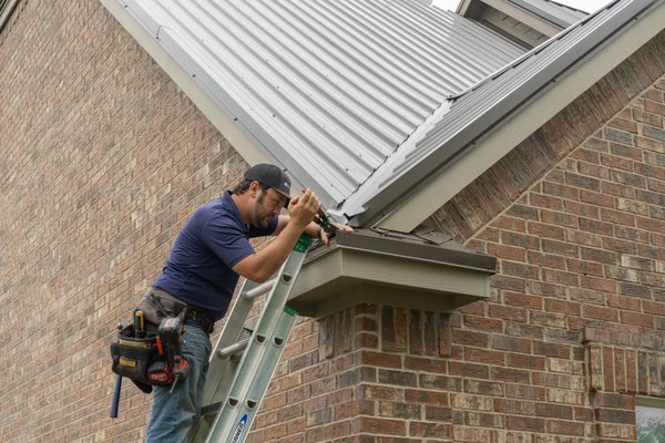Insurance Pays for Most of New Metal Roof - Waxahachie, TX - Hail is a common occurrence in North Texas, damaging thousands of shingle roofs across the DFW metroplex every year. This particular home in Waxahachie, TX is located on a spacious lot in a semi-rural development.
When our hail damage specialist Luke Troyer inspected the roof of this home, he found indications of hail damage.
After the homeowner successfully filed the claim with his insurance company, we scheduled his home for a new metal roof installation.
Typically in these cases, the insurance will pay the amount that it would cost to replace the damaged shingles with new shingles. Since metal does cost more, this homeowner paid $5000 to upgrade his roof to a lifetime metal roof.
We installed the Panel-Loc Plus system on this home. It’s an attractive, durable, and cost effective panel, perfect for most of our customers. The homeowner selected Burnished Slate, one of our most popular colors.
The first step was to install lath over the existing shingles. This provides a solid anchor point for the screws that fasten the metal panels to the roof. We installed all the correct trims along the edges of the roof, including these decorative corners.
Installing metal panels on a complex roof is challenging, but our team did a great job of making this roof both waterproof and aesthetically pleasing.
While the main reason to upgrade to a metal roof is typically because of their impressive durability, you have to admit this home looks really sharp too! Insurance Pays for Most of New Metal Roof - Waxahachie, TX - Hail is a common occurrence in North Texas, damaging thousands of shingle roofs across the DFW metroplex every year. This particular home in Waxahachie, TX is located on a spacious lot in a semi-rural development.
When our hail damage specialist Luke Troyer inspected the roof of this home, he found indications of hail damage.
After the homeowner successfully filed the claim with his insurance company, we scheduled his home for a new metal roof installation.
Typically in these cases, the insurance will pay the amount that it would cost to replace the damaged shingles with new shingles. Since metal does cost more, this homeowner paid $5000 to upgrade his roof to a lifetime metal roof.
We installed the Panel-Loc Plus system on this home. It’s an attractive, durable, and cost effective panel, perfect for most of our customers. The homeowner selected Burnished Slate, one of our most popular colors.
The first step was to install lath over the existing shingles. This provides a solid anchor point for the screws that fasten the metal panels to the roof. We installed all the correct trims along the edges of the roof, including these decorative corners.
Installing metal panels on a complex roof is challenging, but our team did a great job of making this roof both waterproof and aesthetically pleasing.
While the main reason to upgrade to a metal roof is typically because of their impressive durability, you have to admit this home looks really sharp too!