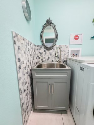 Laundry Room Utility Sink Upgrade - The laundry area was equipped with an outdated, wall-mounted utility sink that lacked cabinet storage and had limited functionality for everyday household use. The open design also left plumbing exposed and reduced the overall visual appeal of the space.
We upgraded the space with a brand-new, cabinet-style utility sink featuring a deep stainless basin, modern high-arc faucet, and enclosed storage below. This installation not only improved durability and usability but also enhanced the room’s appearance with a clean, finished look that complements the existing tile work and layout. Laundry Room Utility Sink Upgrade - The laundry area was equipped with an outdated, wall-mounted utility sink that lacked cabinet storage and had limited functionality for everyday household use. The open design also left plumbing exposed and reduced the overall visual appeal of the space.
We upgraded the space with a brand-new, cabinet-style utility sink featuring a deep stainless basin, modern high-arc faucet, and enclosed storage below. This installation not only improved durability and usability but also enhanced the room’s appearance with a clean, finished look that complements the existing tile work and layout.