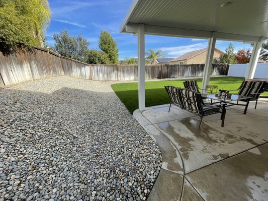 Dark Blend Artificial Turf with Yosemite River Rock - Our client was absolutely done with all the mud their dog and kids would track in from the sod so they opted for turf. We installed our Bantam Dark Blend Artificial Turf and surrounded it with their choice of River Rock.
