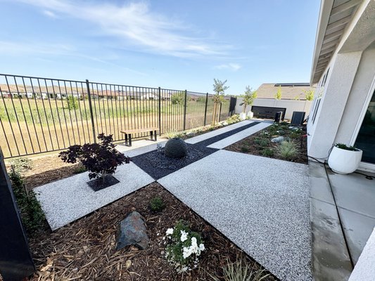 El Dorado Hills New Development - This beautiful backyard in El Dorado Hills was designed by the homeowner's son. The white walkways/patio were created from Oyster Shell, contrasted agains black Mexican Pebbles. The project included many low water and native CA plants.