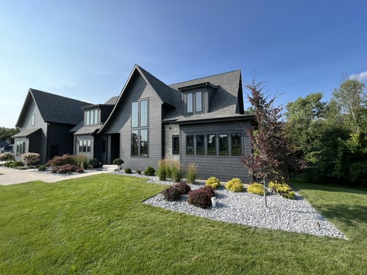 Landscape Bed: Mulch Replacement with Gray Slate Stone Ground Cover - This renovation was done in a beautiful neighborhood in Ada, Michigan. Our team removed the existing, worn out mulch, laid down landscape fabric to prevent weed growth in the beds, and then installed 8 tons of gray slate stone ground cover. The owner was ecstatic with the results especially noting the improved aesthetic appeal and reduced maintenance for years to come. Landscape Bed: Mulch Replacement with Gray Slate Stone Ground Cover - This renovation was done in a beautiful neighborhood in Ada, Michigan. Our team removed the existing, worn out mulch, laid down landscape fabric to prevent weed growth in the beds, and then installed 8 tons of gray slate stone ground cover. The owner was ecstatic with the results especially noting the improved aesthetic appeal and reduced maintenance for years to come.