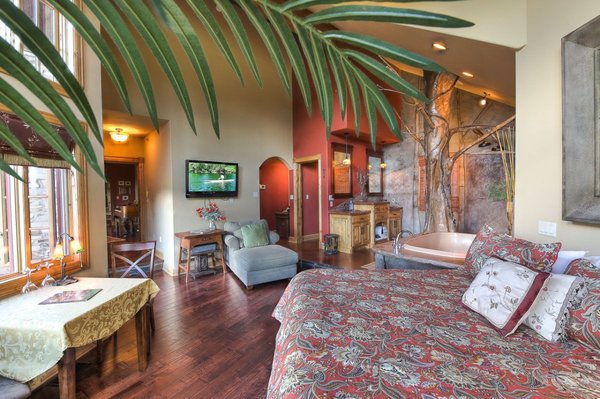 Grand Arbor Room at Talus Rock Retreat - Talus Rock’s Signature Suite: The Grand Arbor! Often chosen as the honeymoon or anniversary suite, this heavenly, romantic, open-air style space features a jetted tub for two, king bed, an octagonal 30-foot copper ceiling, and a one-of-a-kind double-headed tree shower. Open the French doors to a private deck, step outside and be surrounded by the gorgeous backdrop of the majestic Cabinet Mountains.