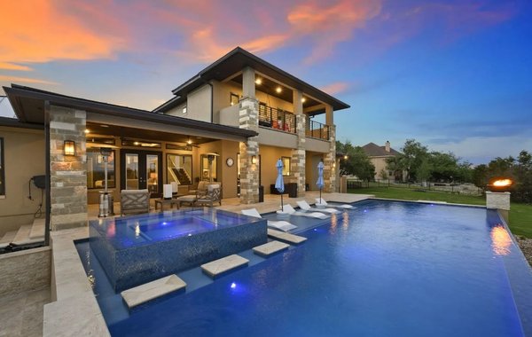 Flame Finished Pool Designed with Relaxation in Mind! - The striking blue color of this pool perfectly showcases our flamed finish interior surface.  This interior is the highest grade interior finish available.  The pool was designed to seamlessly integrate with their pre-existing outdoor living space.  The addition of the firebowls, lounge area, and spa make this pool a one-stop shop for total relaxation!