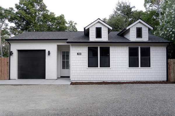 Custom ADU New Build – Modern & Functional Living - Wilson Construction Co. designed and built this accessory dwelling unit (ADU) with both style and efficiency in mind. Featuring a bright and airy kitchen with custom wood cabinetry, modern fixtures, and vaulted ceilings, this ADU maximizes space without compromising design. The exterior’s crisp white siding and black accents create a modern farmhouse feel, making this home addition as beautiful as it is practical.
