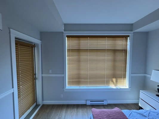 Faux Wood Blinds - Our faux wood blinds provide the timeless beauty of real wood with added durability and affordability. These blinds are resistant to moisture, warping, and fading, making them perfect for kitchens, bathrooms, and high-humidity areas. They offer excellent light control and privacy, with the ability to tilt the slats to adjust the amount of light entering the room. Available in a range of woodgrain finishes and colors, faux wood blinds complement any décor. Custom-fit to your windows and available with Cordless Controls, these blinds combine the classic look of wood with modern functionality and ease of maintenance. Faux Wood Blinds - Our faux wood blinds provide the timeless beauty of real wood with added durability and affordability. These blinds are resistant to moisture, warping, and fading, making them perfect for kitchens, bathrooms, and high-humidity areas. They offer excellent light control and privacy, with the ability to tilt the slats to adjust the amount of light entering the room. Available in a range of woodgrain finishes and colors, faux wood blinds complement any décor. Custom-fit to your windows and available with Cordless Controls, these blinds combine the classic look of wood with modern functionality and ease of maintenance.