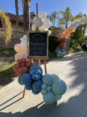 Rosemary & Cody’s Wedding - We had the honor of orchestrating our first wedding for a couple embarking on a whimsical journey into eternity.
With a touch of magic, we adorned the entrance with a magnificent balloon arch, serving as a gateway to a realm of love and enchantment. And behold, the welcome sign, adorned with an organic garland, inviting guests to step into a world of wonder and joy.
Now imagine your own love story unfolding in such a magical setting. Let me sprinkle some joy and magic into your wedding day, creating memories that will sparkle in your hearts for eternity. Rosemary & Cody’s Wedding - We had the honor of orchestrating our first wedding for a couple embarking on a whimsical journey into eternity.
With a touch of magic, we adorned the entrance with a magnificent balloon arch, serving as a gateway to a realm of love and enchantment. And behold, the welcome sign, adorned with an organic garland, inviting guests to step into a world of wonder and joy.
Now imagine your own love story unfolding in such a magical setting. Let me sprinkle some joy and magic into your wedding day, creating memories that will sparkle in your hearts for eternity.